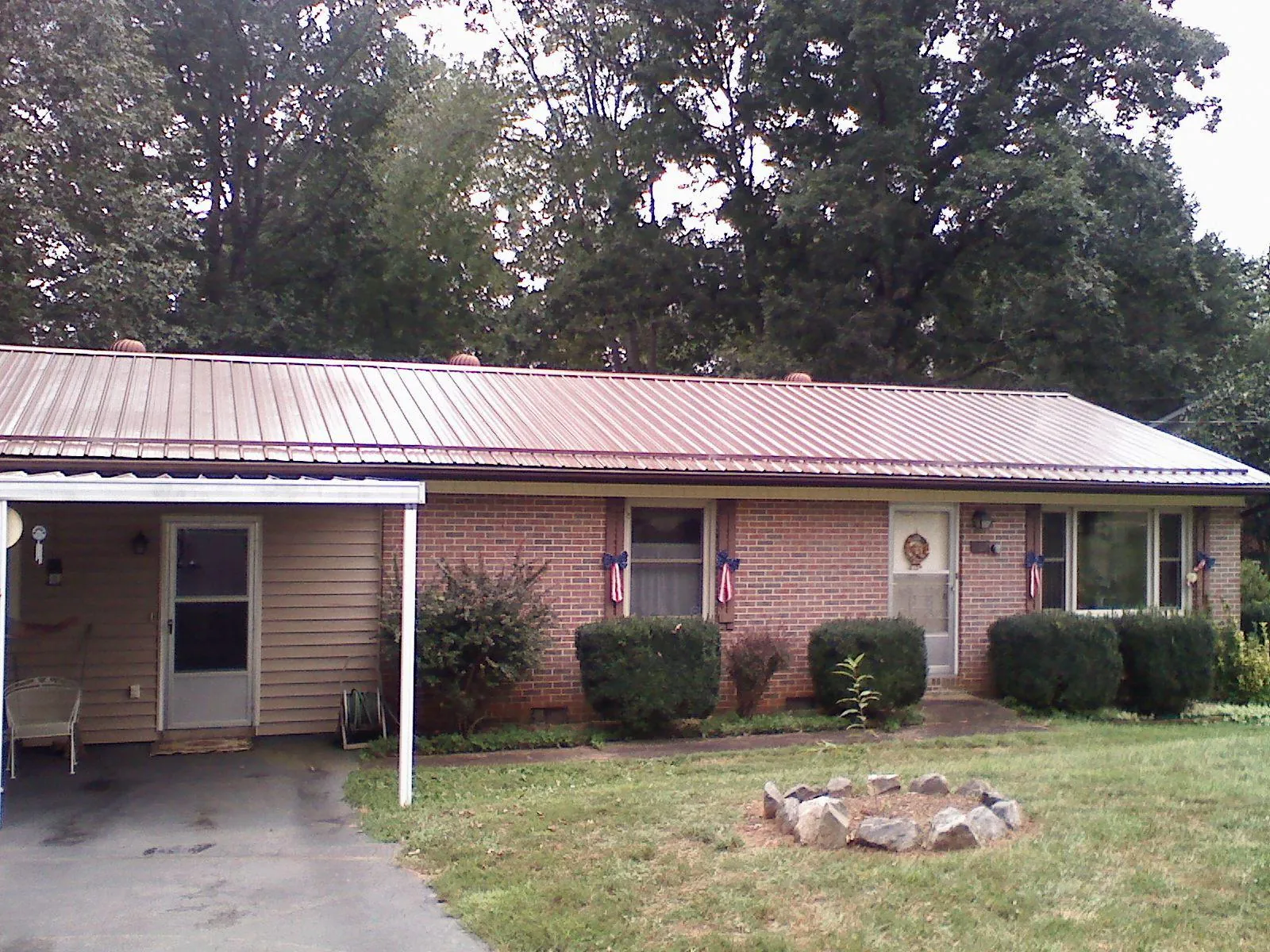 Bronze metal roof and carport on a brick ranch home — Roof Repair work by our crew in Ava